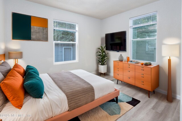 736 W St, Jacksonville, FL 32204 - bedroom with multiple windows, light wood-type flooring, and baseboards