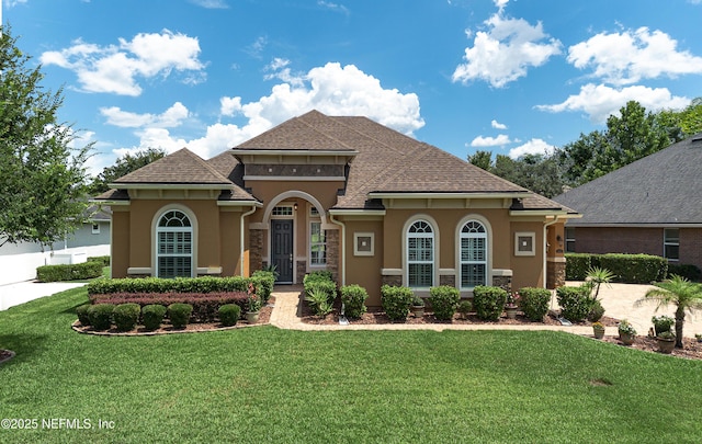 3653 Oglebay Dr, Green Cove Springs, FL 32043 - mediterranean / spanish-style house with stucco siding, a front lawn, and stone siding