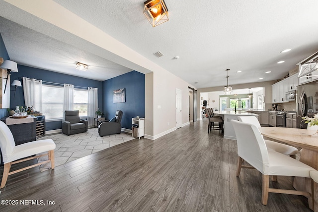 212 Foxcross Ave, Saint Johns, FL 32092 - living room featuring wood finished floors, a textured ceiling, baseboards, and recessed lighting
