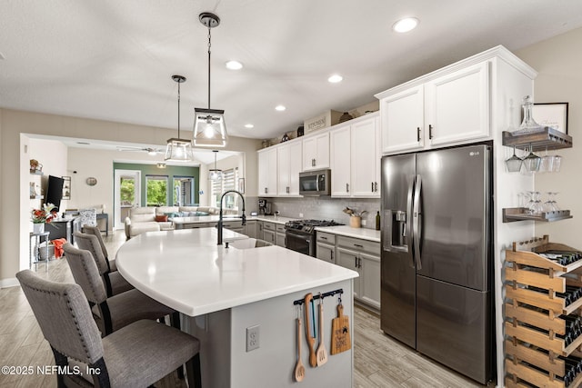 212 Foxcross Ave, Saint Johns, FL 32092 - kitchen featuring stainless steel appliances, a sink, light wood-style floors, a kitchen breakfast bar, and open floor plan