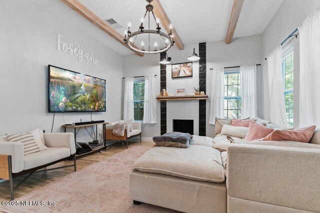 3040 Rosselle St, Jacksonville, FL 32205 - living room featuring a chandelier, beam ceiling, wood finished floors, and a tiled fireplace