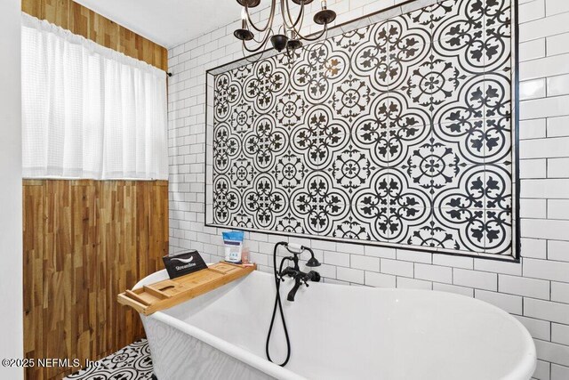 3040 Rosselle St, Jacksonville, FL 32205 - bathroom featuring tile walls, a freestanding tub, a chandelier, and wooden walls