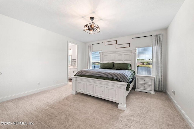 154 Pine Candle Way, Saint Augustine, FL 32092 - bedroom with multiple windows, light colored carpet, baseboards, and ensuite bath