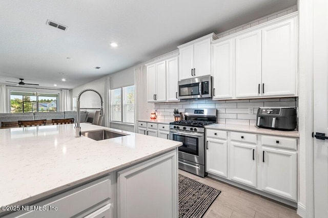 154 Pine Candle Way, Saint Augustine, FL 32092 - kitchen with appliances with stainless steel finishes, a sink, tasteful backsplash, white cabinetry, and recessed lighting