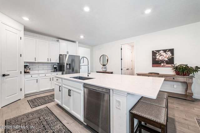 154 Pine Candle Way, Saint Augustine, FL 32092 - kitchen featuring stainless steel appliances, a sink, an island with sink, white cabinets, and backsplash
