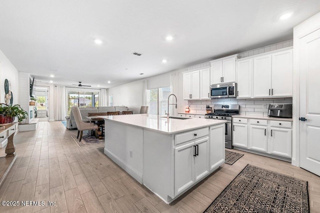 154 Pine Candle Way, Saint Augustine, FL 32092 - kitchen featuring appliances with stainless steel finishes, a sink, light wood-type flooring, recessed lighting, and a center island with sink