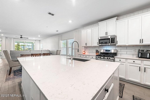 154 Pine Candle Way, Saint Augustine, FL 32092 - kitchen with stainless steel appliances, a sink, light wood-type flooring, backsplash, and recessed lighting