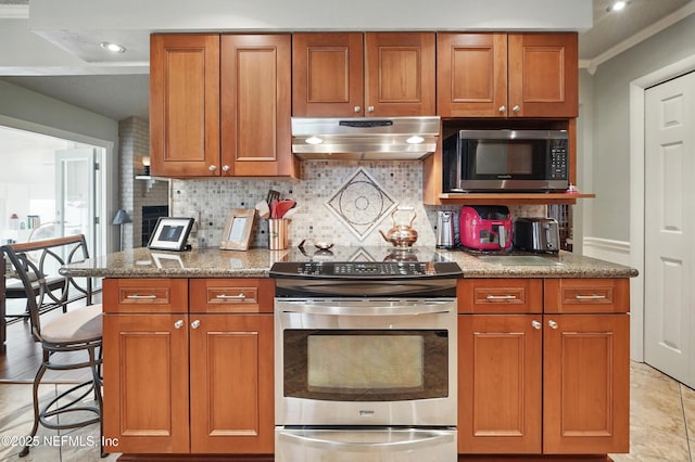 11019 Crumpet Ct, Jacksonville, FL 32257 - kitchen featuring appliances with stainless steel finishes, ventilation hood, decorative backsplash, brown cabinetry, and ornamental molding