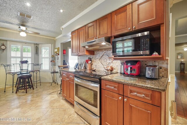 11019 Crumpet Ct, Jacksonville, FL 32257 - kitchen featuring under cabinet range hood, appliances with stainless steel finishes, ornamental molding, baseboards, and ceiling fan