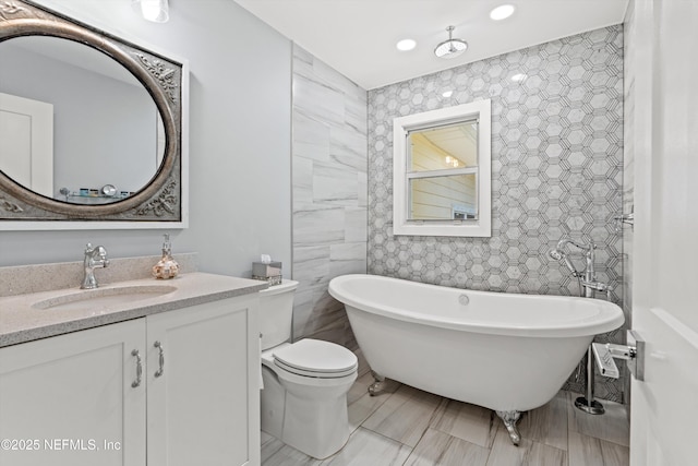 536 14th Ave N, Jacksonville Beach, FL 32250 - full bath featuring a freestanding bath, vanity, recessed lighting, tile walls, and toilet