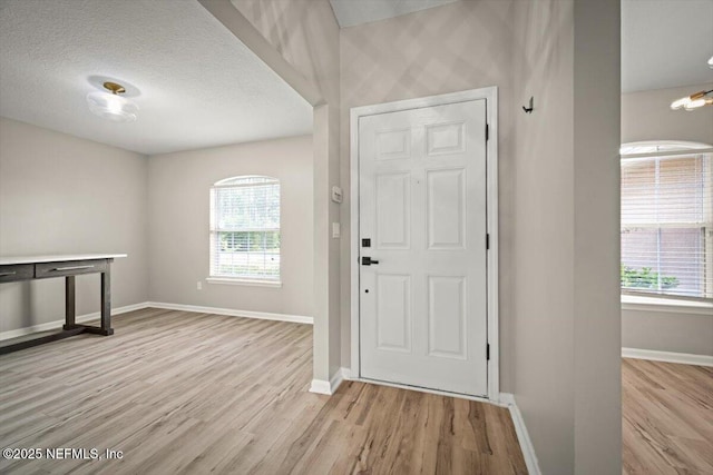86045 Harrahs Pl, Yulee, FL 32097 - foyer with baseboards, wood finished floors, healthy amount of natural light, and a textured ceiling