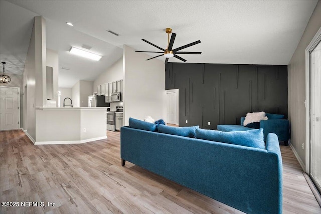 86045 Harrahs Pl, Yulee, FL 32097 - living room featuring light wood-type flooring, vaulted ceiling, baseboards, and ceiling fan