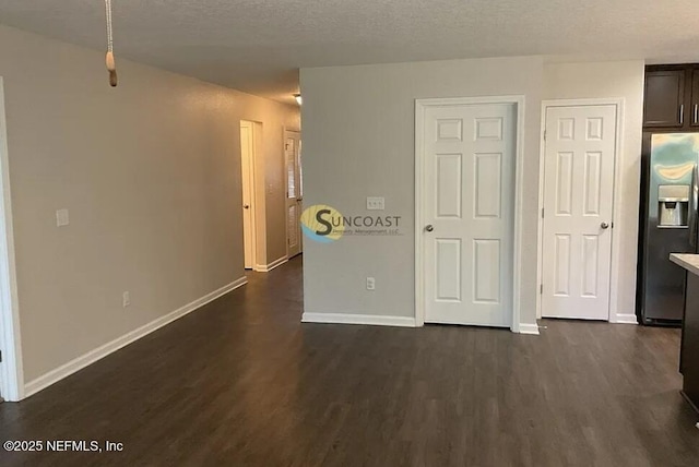 7323 Richardson Rd, Jacksonville, FL 32209 - unfurnished bedroom with stainless steel fridge, dark wood-type flooring, baseboards, and a textured ceiling