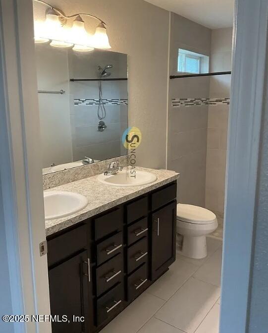 7323 Richardson Rd, Jacksonville, FL 32209 - full bath with double vanity, tiled shower, toilet, and tile patterned flooring
