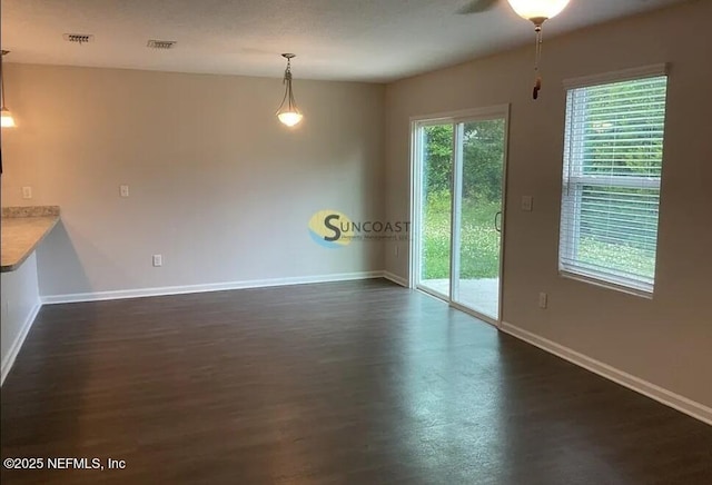 7323 Richardson Rd, Jacksonville, FL 32209 - unfurnished dining area featuring baseboards and dark wood-type flooring