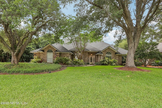 2478 Country Club Blvd, Orange Park, FL 32073 - view of front of property featuring a front yard, a shingled roof, stone siding, and brick siding