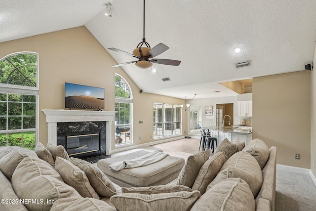 2478 Country Club Blvd, Orange Park, FL 32073 - living area with high vaulted ceiling, ceiling fan, baseboards, a textured ceiling, and a high end fireplace