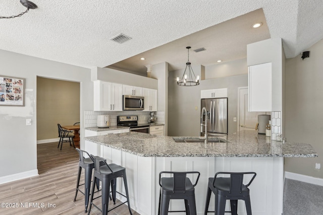 2478 Country Club Blvd, Orange Park, FL 32073 - kitchen with stainless steel appliances, a sink, baseboards, decorative backsplash, and a peninsula