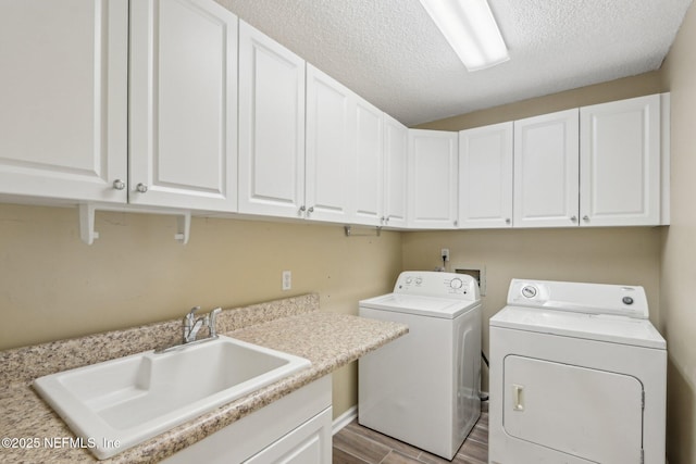 2478 Country Club Blvd, Orange Park, FL 32073 - laundry room with washing machine and dryer, cabinet space, light wood-style floors, and a textured ceiling