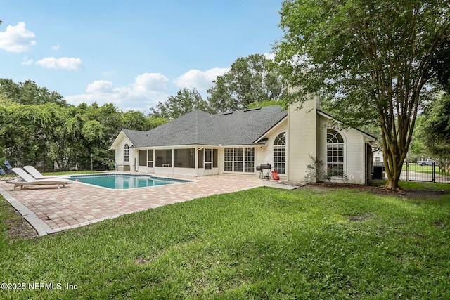 2478 Country Club Blvd, Orange Park, FL 32073 - back of house with a sunroom, a patio area, a chimney, and roof with shingles