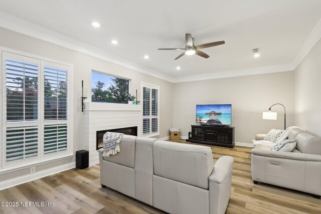 182 Malley Cove Ln, Fleming Island, FL 32003 - living area featuring ceiling fan, crown molding, light wood-type flooring, recessed lighting, and a glass covered fireplace