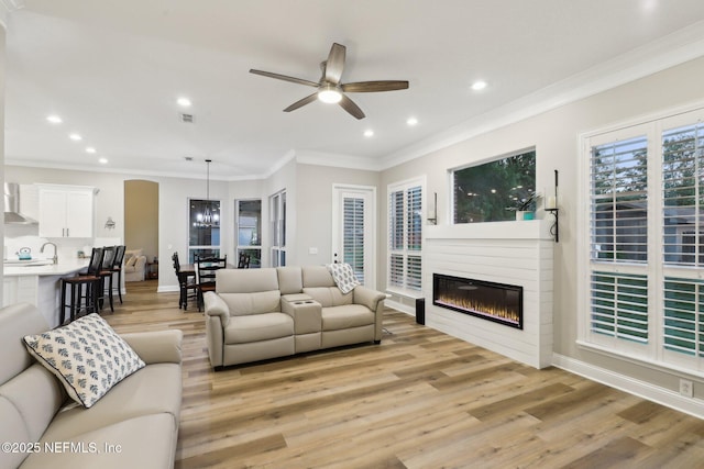 182 Malley Cove Ln, Fleming Island, FL 32003 - living area featuring recessed lighting, light wood-type flooring, ceiling fan, ornamental molding, and a glass covered fireplace