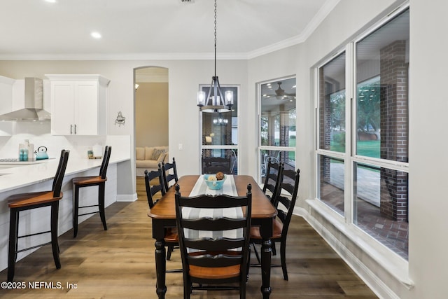 182 Malley Cove Ln, Fleming Island, FL 32003 - dining room featuring ornamental molding, arched walkways, dark wood-style flooring, baseboards, and a chandelier