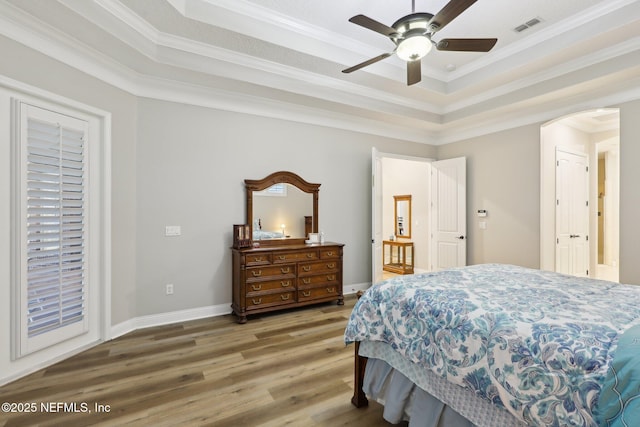 182 Malley Cove Ln, Fleming Island, FL 32003 - bedroom with wood finished floors, ornamental molding, a tray ceiling, baseboards, and ceiling fan