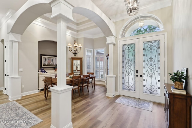 182 Malley Cove Ln, Fleming Island, FL 32003 - foyer entrance featuring a chandelier, french doors, arched walkways, light wood-style floors, and crown molding