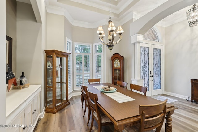 182 Malley Cove Ln, Fleming Island, FL 32003 - dining space with a chandelier, arched walkways, french doors, light wood-style flooring, and a towering ceiling