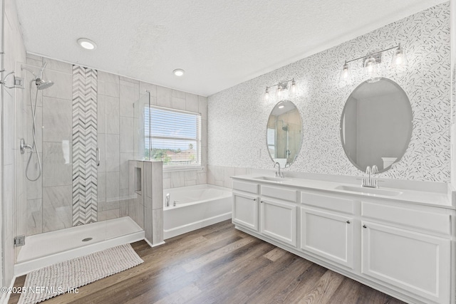 1578 Harvest Cove Dr, Middleburg, FL 32068 - bathroom with a textured ceiling, a garden tub, double vanity, tiled shower, and wood finished floors