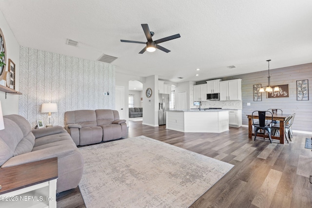 1578 Harvest Cove Dr, Middleburg, FL 32068 - living area with a chandelier, ceiling fan, dark wood finished floors, baseboards, and a textured ceiling