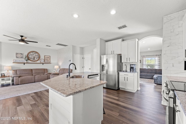 1578 Harvest Cove Dr, Middleburg, FL 32068 - kitchen featuring stainless steel appliances, a sink, open floor plan, arched walkways, and a textured ceiling