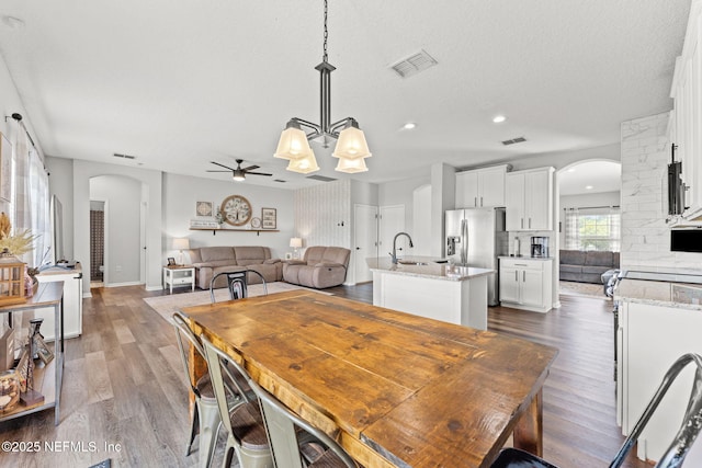 1578 Harvest Cove Dr, Middleburg, FL 32068 - dining space featuring arched walkways, a ceiling fan, dark wood-type flooring, recessed lighting, and a textured ceiling