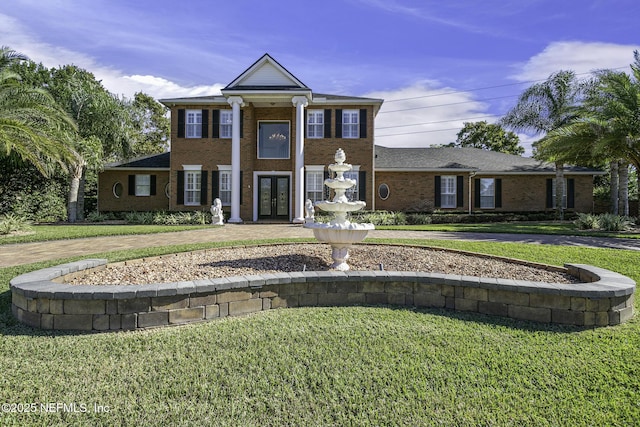 8135 Wekiva Way, Jacksonville, FL 32256 - greek revival inspired property with french doors, a front yard, brick siding, and curved driveway