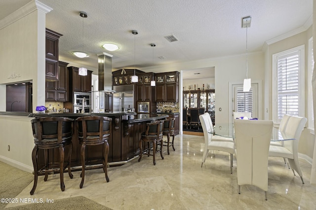 8135 Wekiva Way, Jacksonville, FL 32256 - kitchen with range hood, dark brown cabinetry, a peninsula, decorative backsplash, and a breakfast bar area