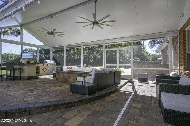 8135 Wekiva Way, Jacksonville, FL 32256 - sunroom / solarium with ceiling fan, an outdoor kitchen, an outdoor hangout area, rail lighting, and lofted ceiling