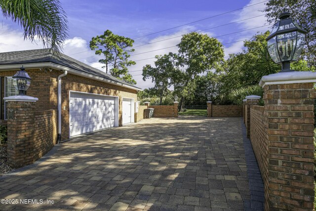 8135 Wekiva Way, Jacksonville, FL 32256 - garage featuring decorative driveway and a gate