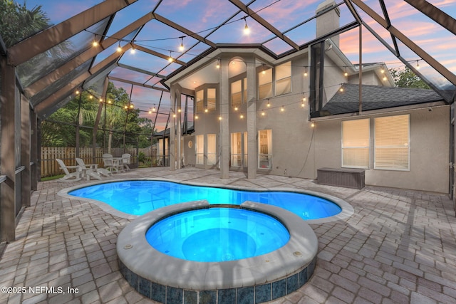 1612 Inkberry Ln, Saint Johns, FL 32259 - pool at dusk featuring a patio, a pool with connected hot tub, and glass enclosure