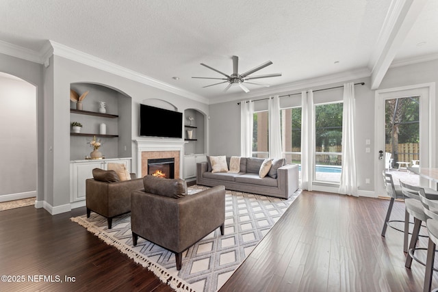1612 Inkberry Ln, Saint Johns, FL 32259 - living area with a tile fireplace, a textured ceiling, dark wood-type flooring, ceiling fan, and arched walkways