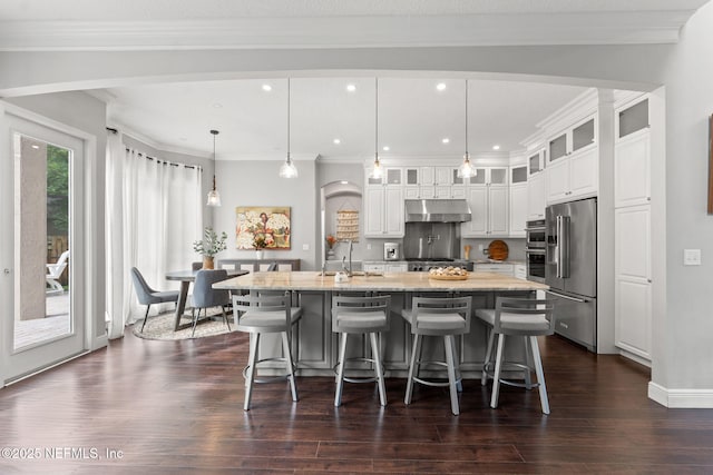 1612 Inkberry Ln, Saint Johns, FL 32259 - kitchen featuring under cabinet range hood, high end fridge, arched walkways, a large island with sink, and dark wood finished floors