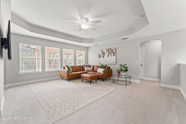 1612 Inkberry Ln, Saint Johns, FL 32259 - living room featuring arched walkways, ceiling fan, a tray ceiling, and light colored carpet
