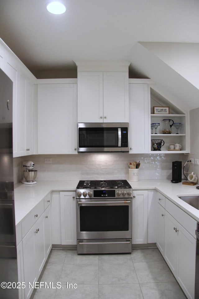 760 Cherry Elm Dr, Saint Augustine, FL 32092 - kitchen with appliances with stainless steel finishes, backsplash, open shelves, light countertops, and white cabinetry