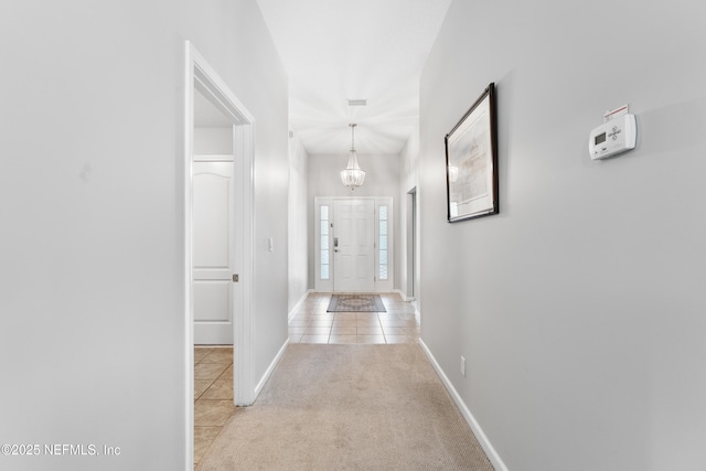 11521 Dunforth Cove Dr, Jacksonville, FL 32218 - corridor with a chandelier, tile patterned floors, carpet floors, and baseboards