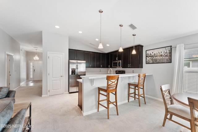 11521 Dunforth Cove Dr, Jacksonville, FL 32218 - kitchen featuring stainless steel appliances, a kitchen breakfast bar, light countertops, a peninsula, and light carpet