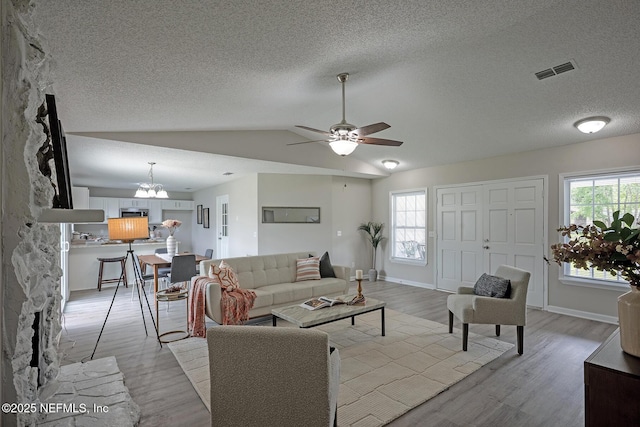 1798 Shannon Lake Dr, Middleburg, FL 32068 - living room featuring light wood-type flooring, vaulted ceiling, ceiling fan, a textured ceiling, and a chandelier