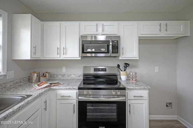 1798 Shannon Lake Dr, Middleburg, FL 32068 - kitchen with appliances with stainless steel finishes, white cabinetry, and light countertops