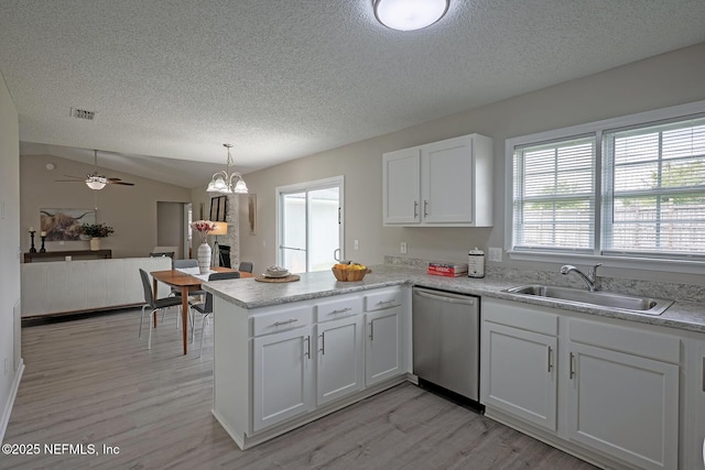 1798 Shannon Lake Dr, Middleburg, FL 32068 - kitchen featuring a sink, stainless steel dishwasher, a peninsula, a textured ceiling, and light wood-style flooring