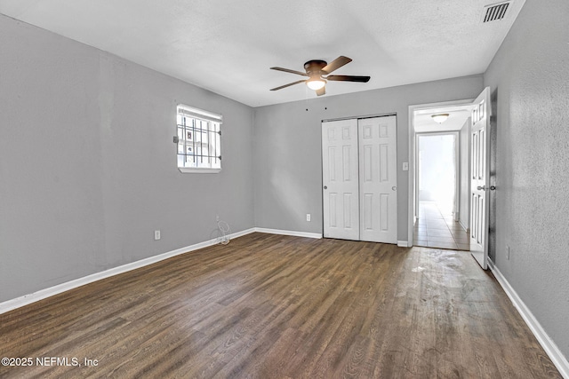 9118 Devonshire Blvd, Jacksonville, FL 32208 - unfurnished bedroom featuring dark wood finished floors, baseboards, a closet, a textured wall, and a ceiling fan