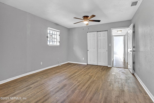 9118 Devonshire Blvd, Jacksonville, FL 32208 - unfurnished bedroom featuring wood finished floors, baseboards, a textured wall, a closet, and a ceiling fan